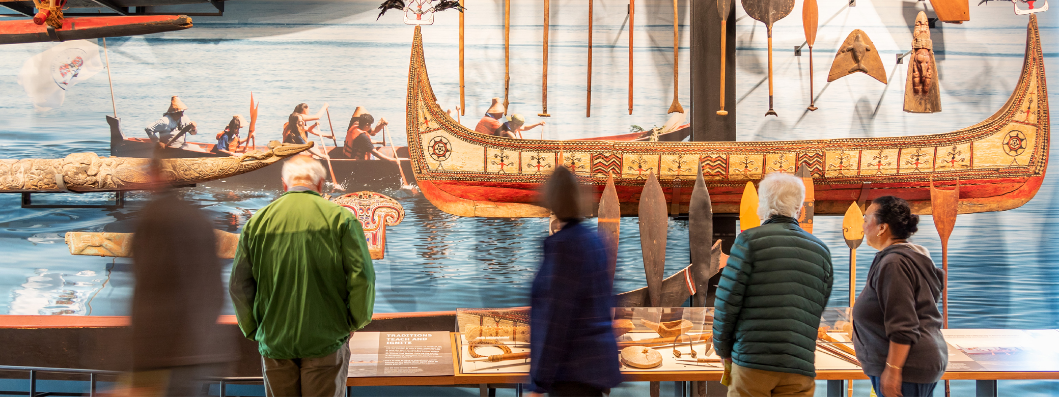 People looking at Indigenous artifacts on display in the Burke Museum