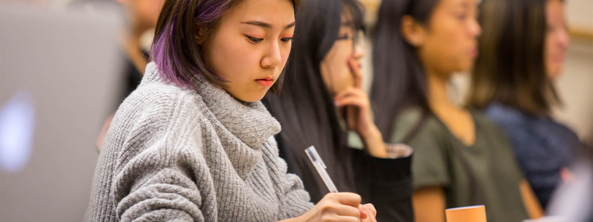 Students take notes and listen during a class discussion.