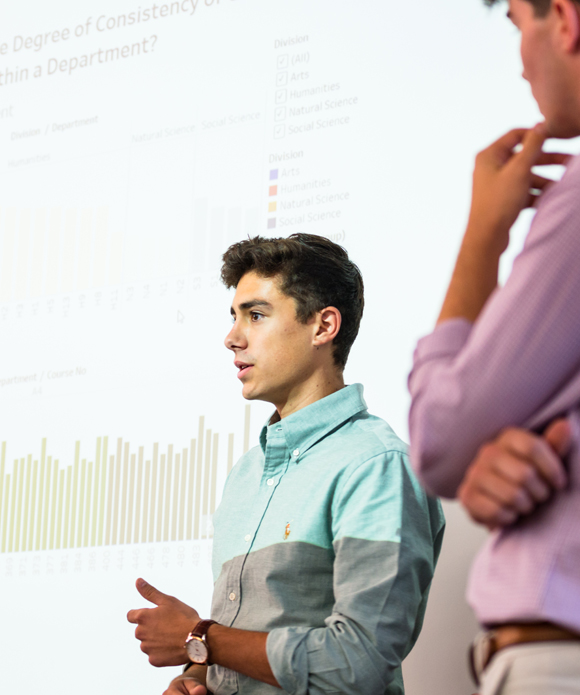 Person presents a graph of data in front of a projector.