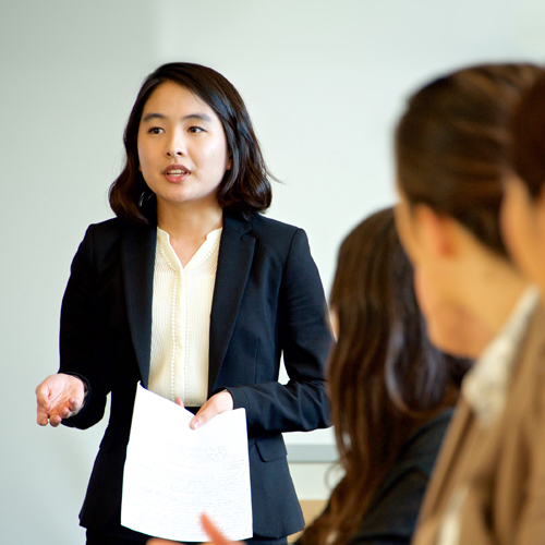 Student in suit giving formal presentation. 