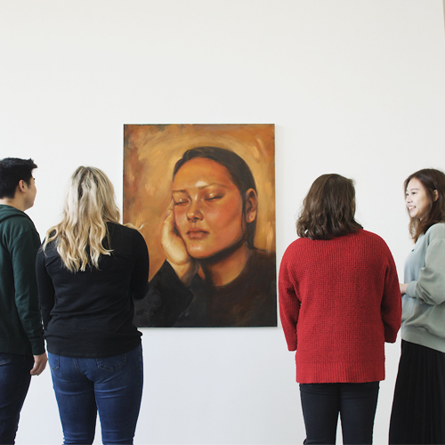 Students looking at a painting in the Jacob Lawrence Gallery.