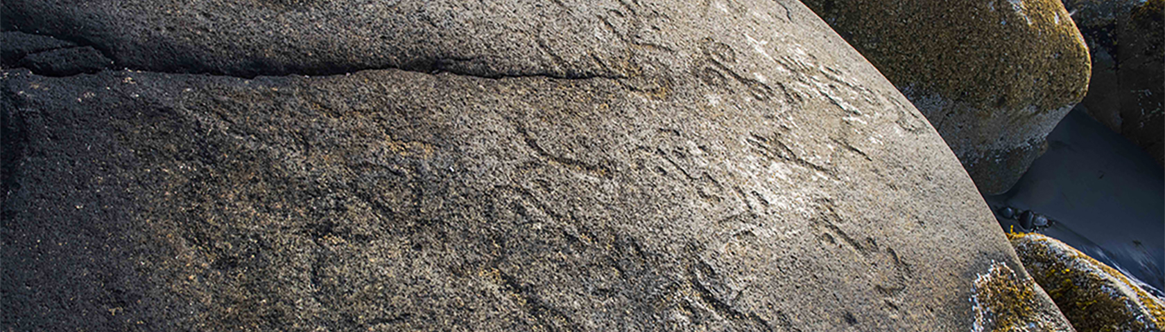 Petroglyphs on rock by shore