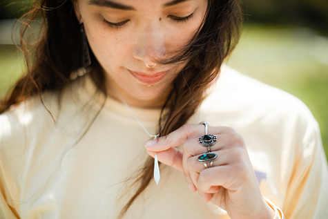 Stephanie Masterman looks at a necklace she designed.