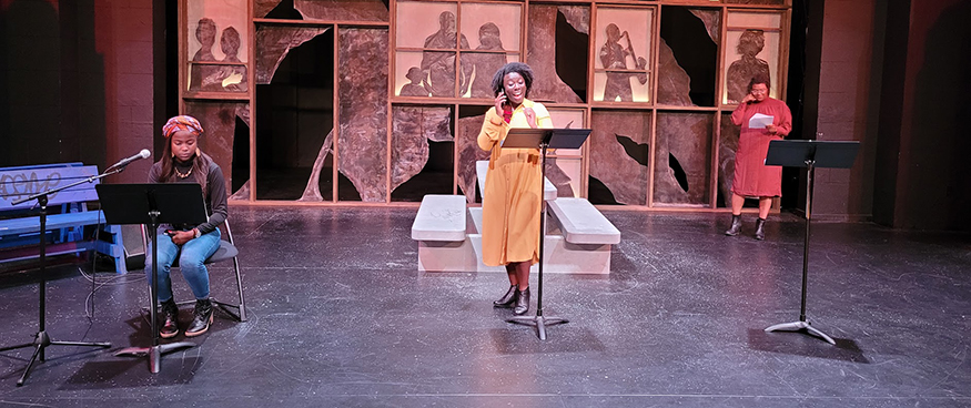 Nikki Yeboah at a podium on stage, with two others joining her on stage.