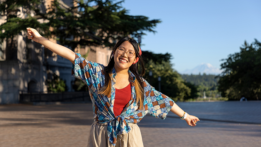 Simona Liao with arms outstretched, on the UW campus.