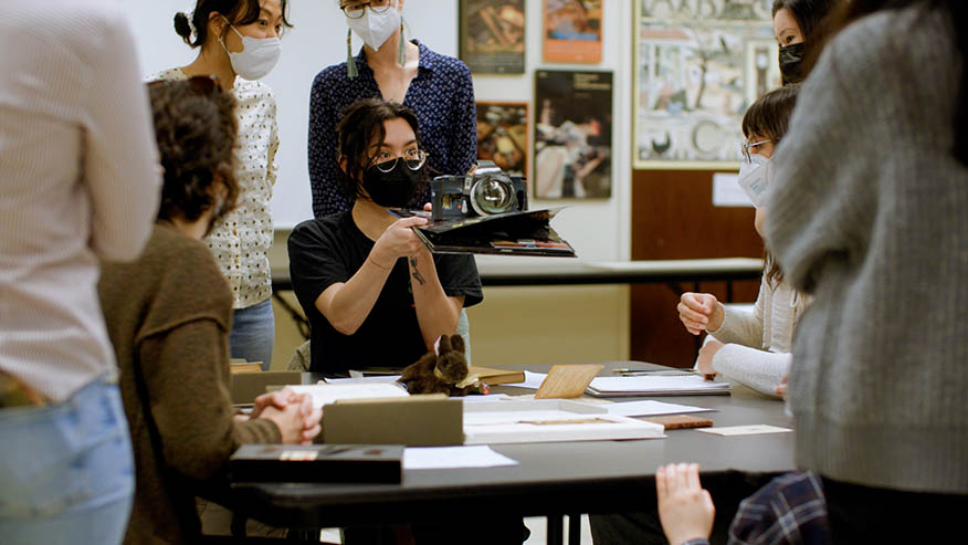 Students looking at model of vintage camera.