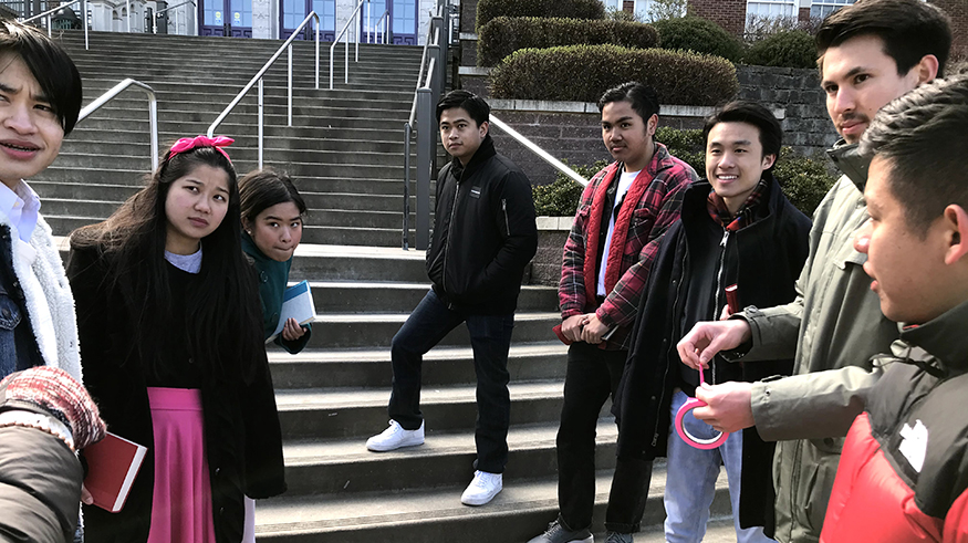 Students standing on the steps outside a high school for a scene for the film version of In a Yellow Tone. 