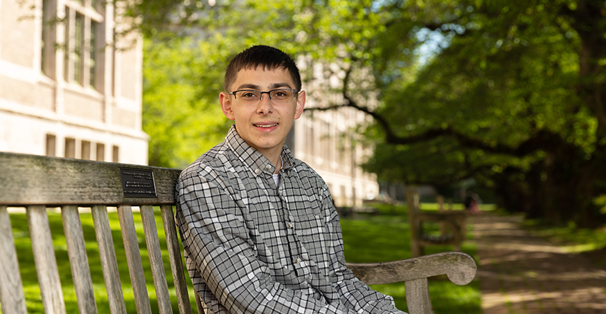 Hayden Goldberg sitting on a bench in the UW quad.