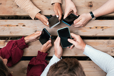 Hands in a circle holding cellphones