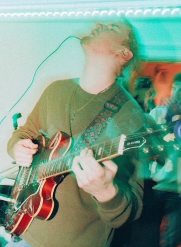 Markus Teuton playing guitar on stage