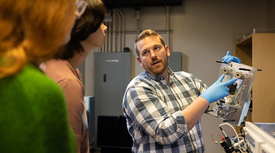 Nick Riley discussing an experiment with students in his lab.