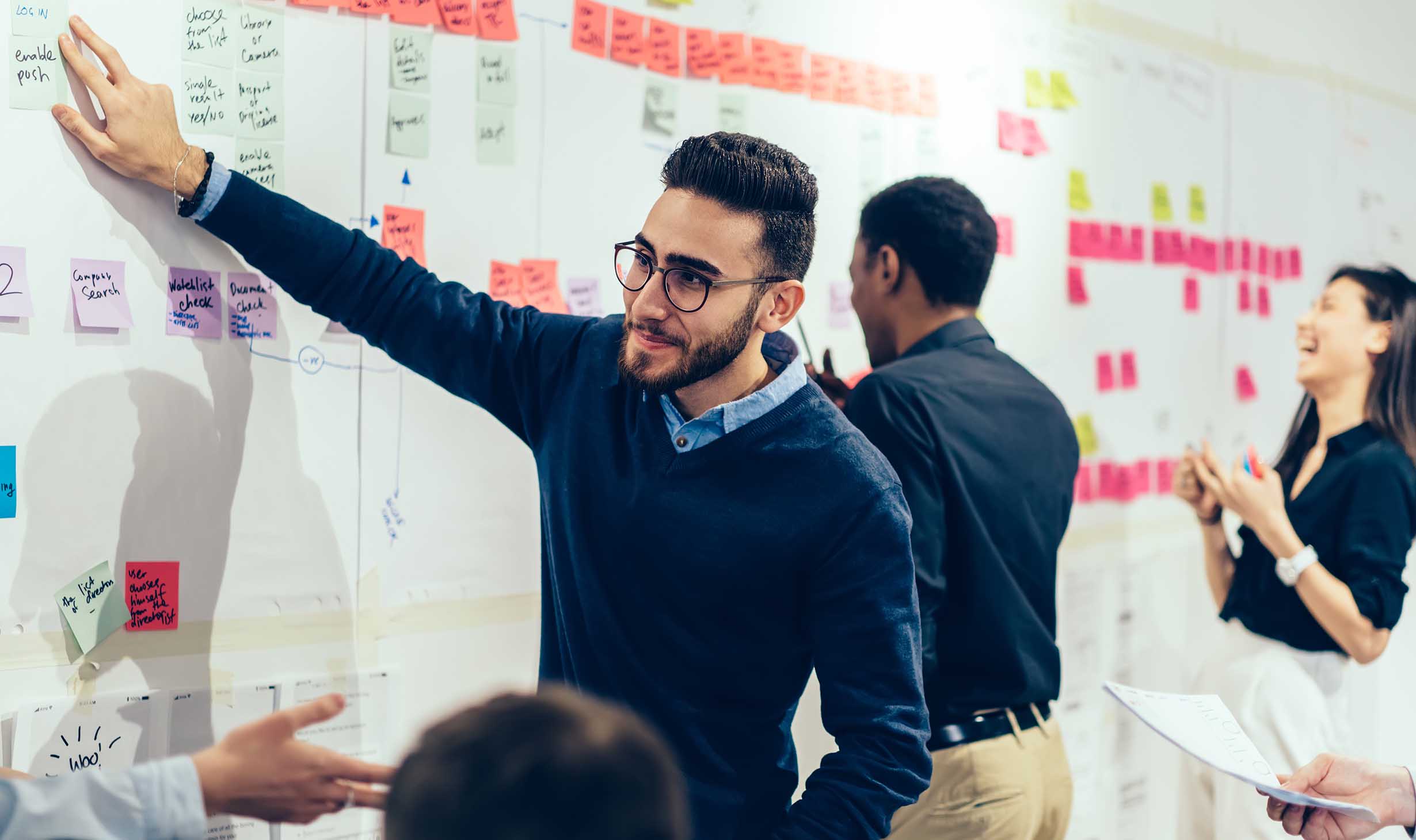 Group of people collaborating at a white board