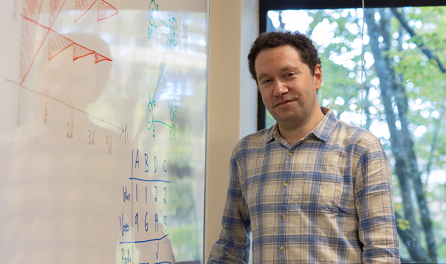 Jonah Ostroff standing next to a whiteboard. 