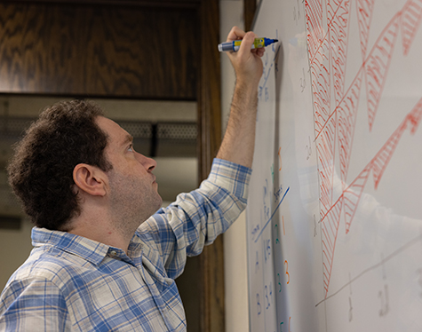 Jonah Ostroff writing on a whiteboard. 